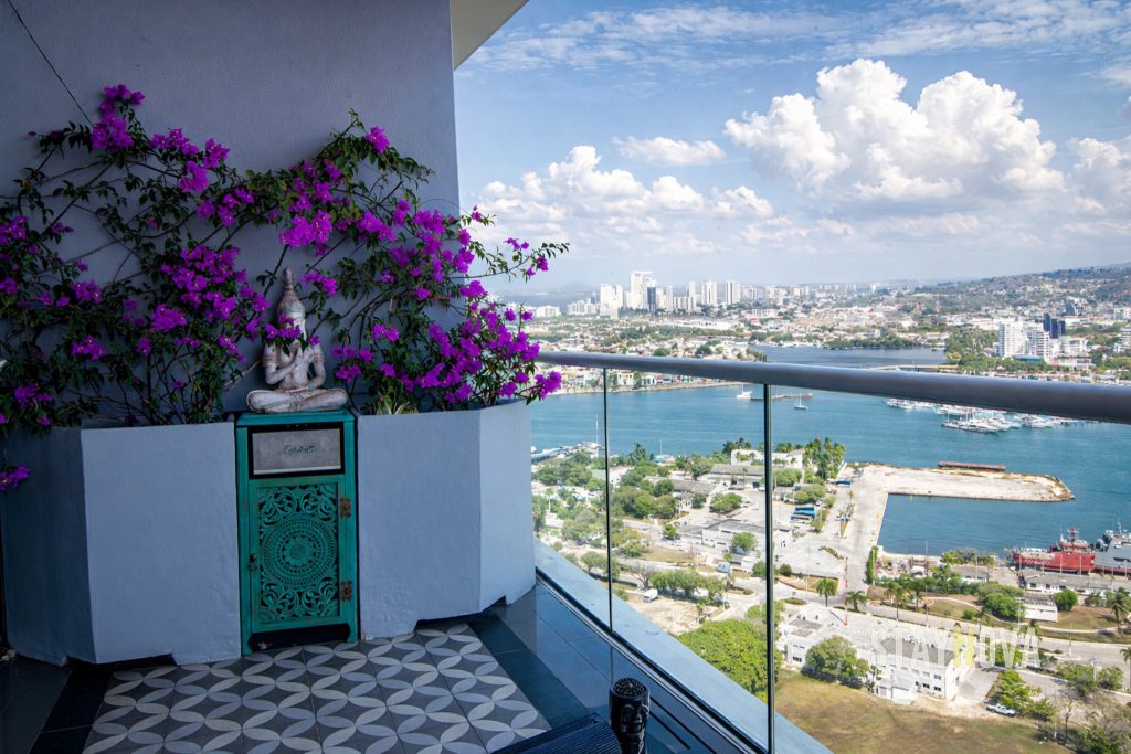 Balcón con flores y vista panorámica a la bahía, en una propiedad de alquiler turístico de Staynova en Cartagena